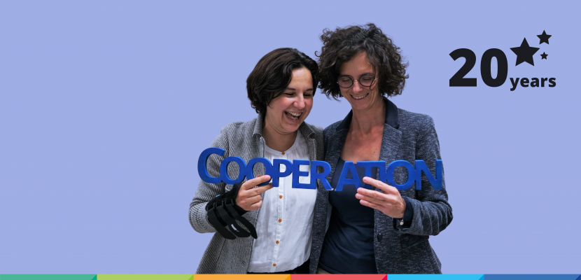 20 years of Interreg Europe celebration Two staff members pose holding a wooden hashtag