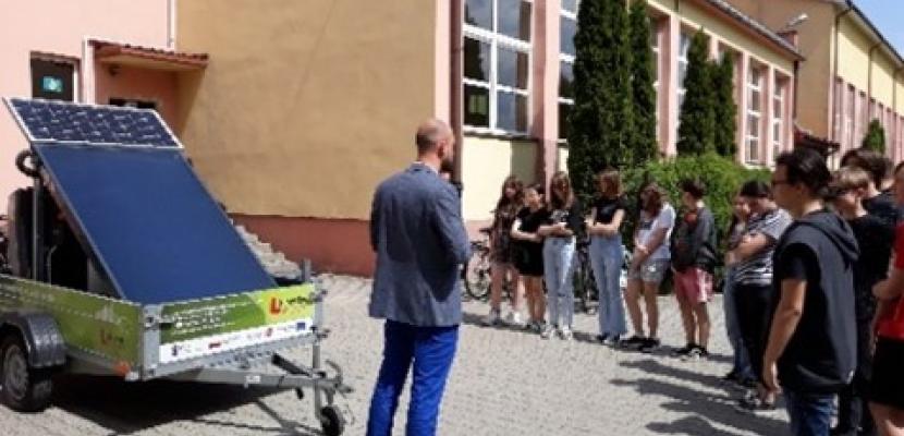 The picture shows children standing in front of the school where the photovoltaic panel is presented