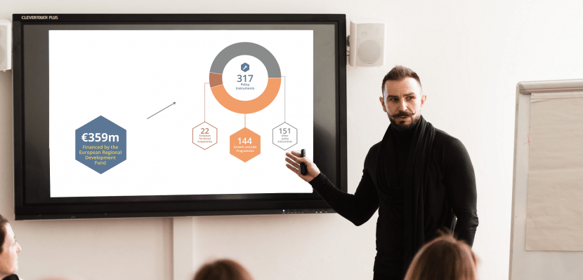 a man presenting facts and figures of the programme Interreg Europe on a screen in front of a audience