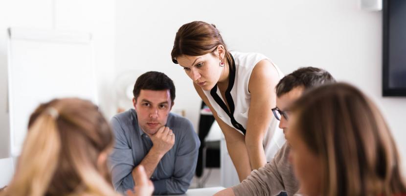 Four people at a table discussing and working