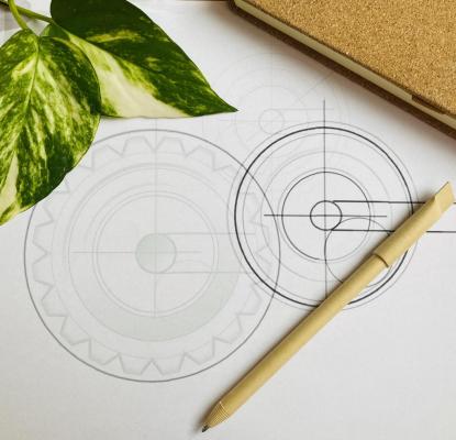 two technical circles, a pencil, cover of the book and a plant