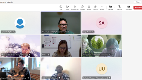 Screenshot of an online meeting featuring multiple participants from different organizations discussing project matters. The participants are shown either on video or represented by initials, with some appearing in separate windows.