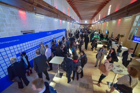 Crowd of people in a hall way networking at an event.