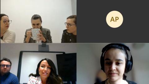 A screenshot of an online meeting with five visible participants in separate video windows. Three participants in the top left window are in discussion, one of whom is drinking from a large mug. The top right window shows a participant's initials, AP. The bottom left window shows two participants, one speaking and the other listening. The bottom right window shows a participant with headphones.