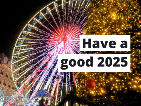 A festive scene featuring a brightly lit Ferris wheel and a large Christmas tree adorned with glowing lights and ornaments. Overlaid text reads, 'Have a good 2025.'