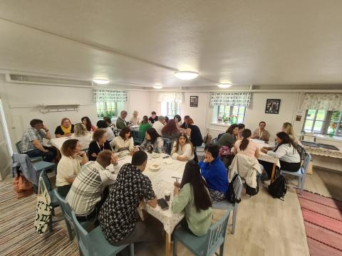 Participants in the "Who is Responsible for Integration?" workshop are actively discussing strategies for immigrant integration, seated around tables with papers, fostering collaborative dialogue.