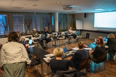 People sitting in a conference room watching a presentation