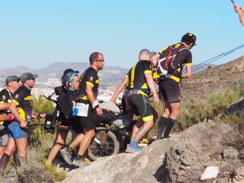 Volunteers with person with disabilty hiking in natural protected areas