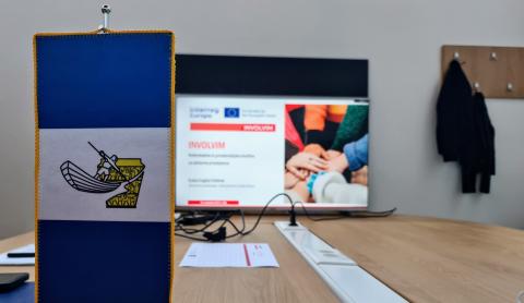 Litija municipality flag, in the back there is an INVOLVIM slide on the monitor. 