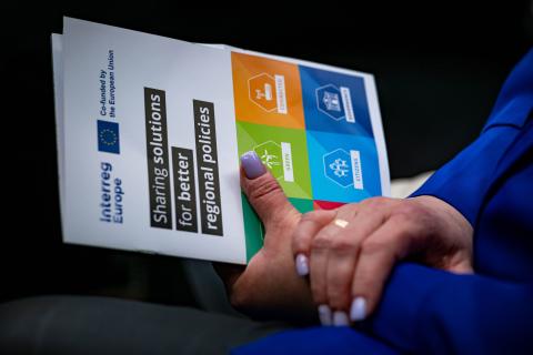 Close up of the hands of a woman holding the Interreg Europe brochure during an event in 2024 Close up of the hands of a woman holding the Interreg Europe brochure during an event in 2024