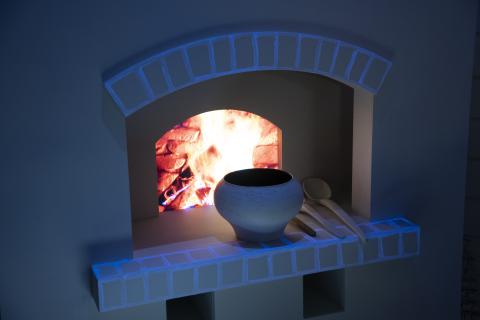 The image shows a virtual fireplace with a simulated fire burning inside. This fireplace is part of an interactive exhibition, allowing visitors to learn about traditional heating methods.