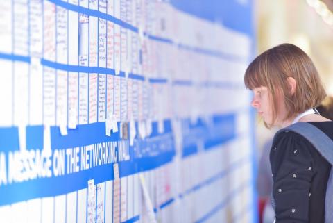 Person taking a looking at wall full of informative cards.