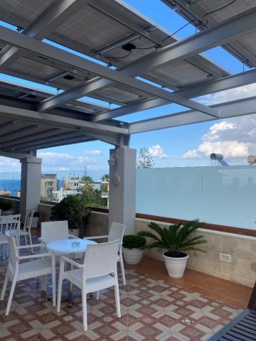 Solar PV panels adorn the rooftop of the Hotel Halepa, where guests can enjoy a cool breeze with a sea view