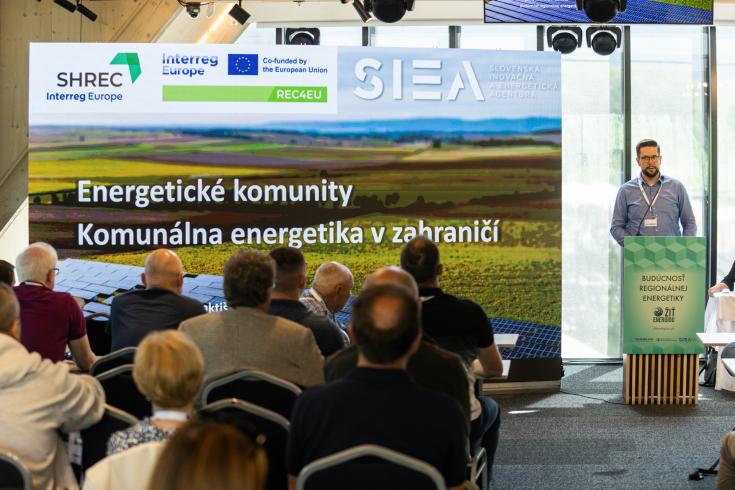 A man (Stanislav from SIEA) standing at the desk presenting Energy Communities