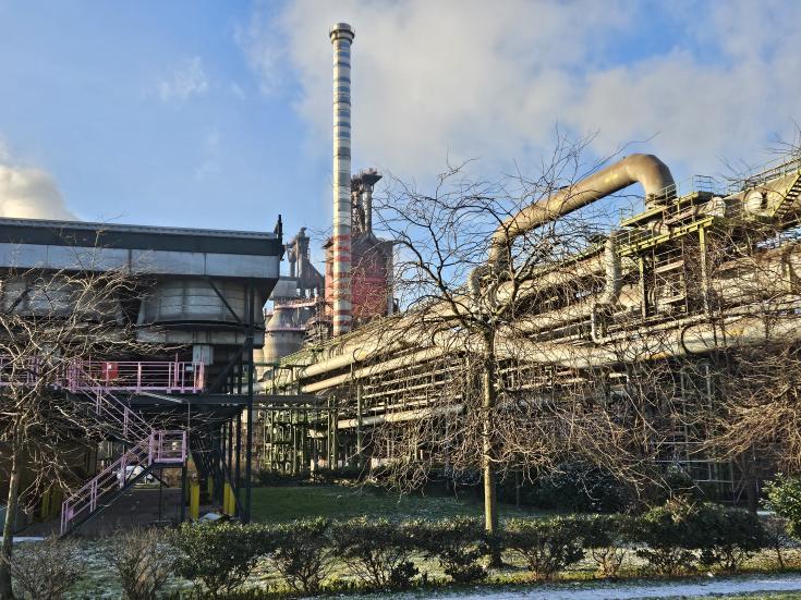 A steel plant with trees in the foreground 