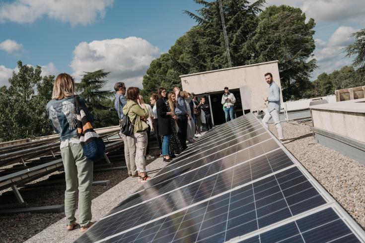 Group of people standing in front of solar panels