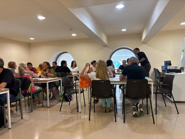 Groups of people sitting at tables discussing project