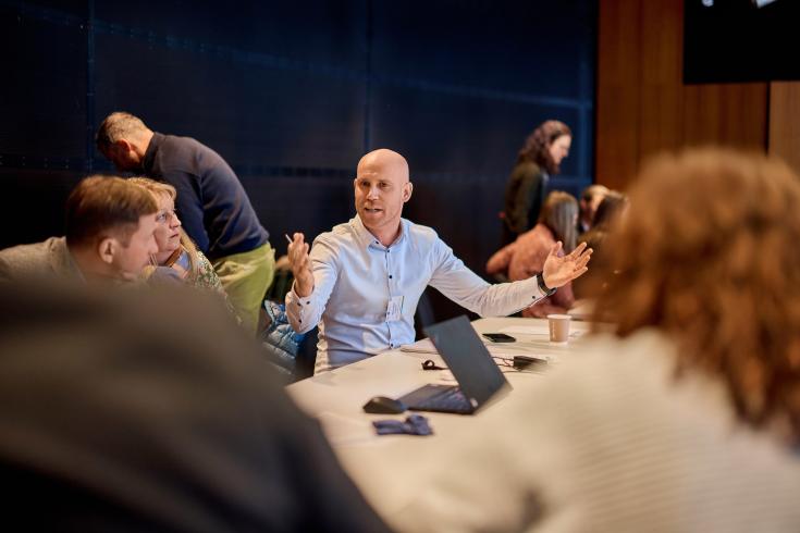 Zoom on man speaking around a table 