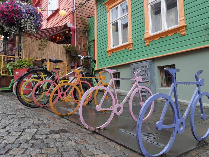 Line of colourful bikes against a green wall Line of colourful bikes against a green wall