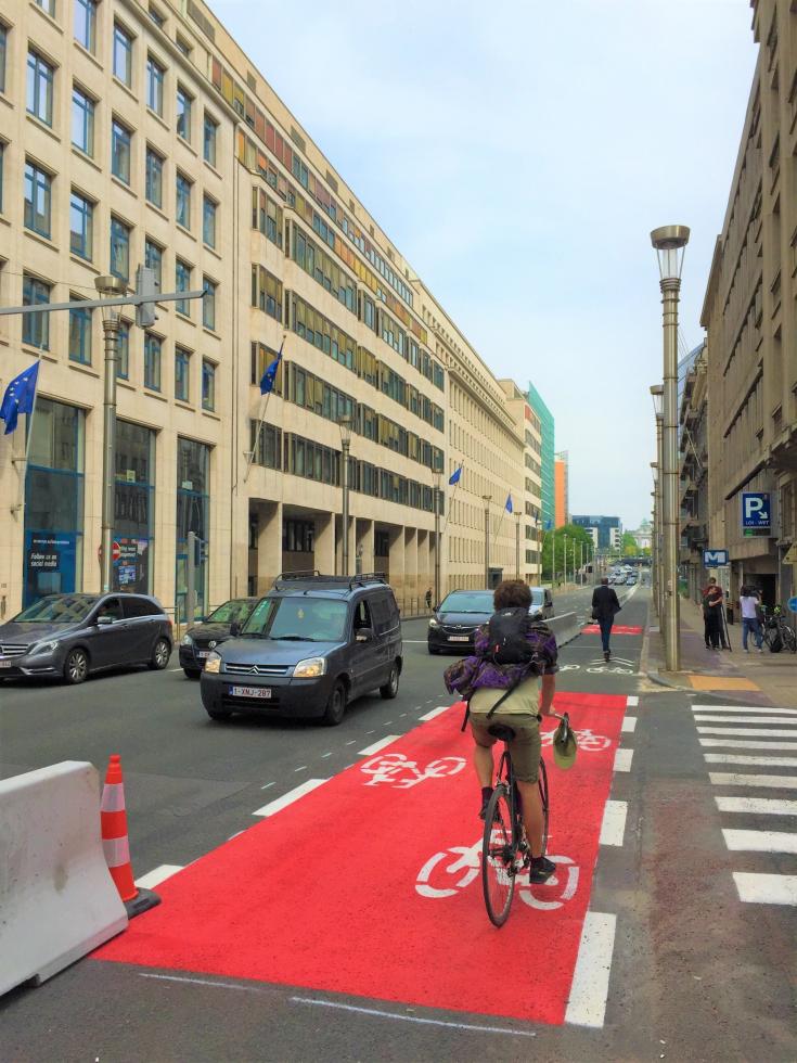 Person biking on biking lane in Brussels Person biking on biking lane in Brussels