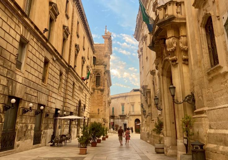 Two people walking in a baroque style street