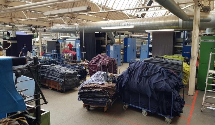Large piles of different textiles in a factory