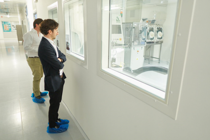 Two people looking at machines through a window