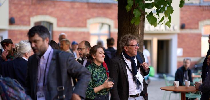 Two people standing in a courtyard smiling Two people standing in a courtyard smiling
