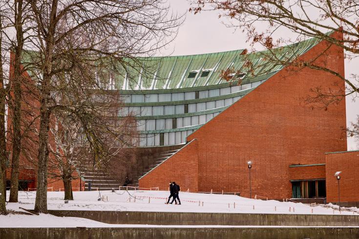 Two people walking in front of building