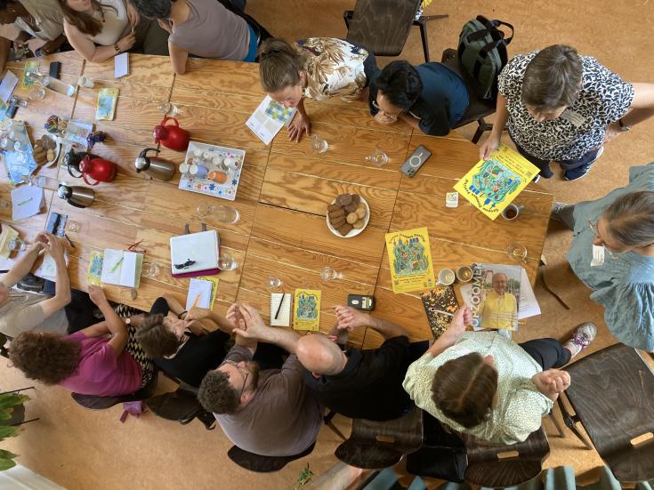 Photo from above of people sitting at a big table and talking to each other