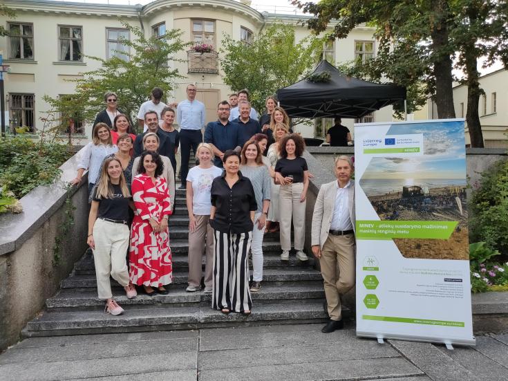 Group of people posing with the MINEV rollup