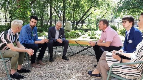 six people talking in a garden 