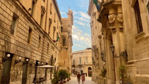 Two people walking in a baroque style street