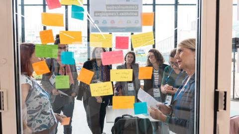 workshop participants looking at colourful post-it notes