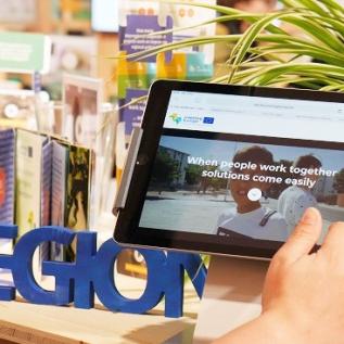 Web documentary explored on tablet at EU Regions Week Close up of web documentary homepage on tablet at Interreg Europe's EU Regions Week stand.