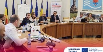 Meeting participants in conversation, seated at a round table.