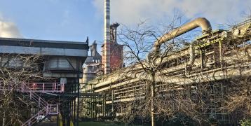 A steel plant with trees in the foreground 