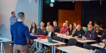 People listening to person presenting People listening to person presenting