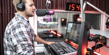 A man talking to a microphone in a recording studio