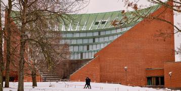 Two people walking in front of building