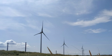 Wind energy turbines with a cloudy blue sky