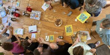 Photo from above of people sitting at a big table and talking to each other