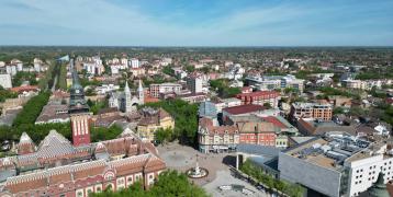 An aerial view of a city with tall buildings in Subotica, Serbia by Anton Lukin