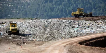 The image shows two excavators in a waste management plant in Manresa, Catalonia.