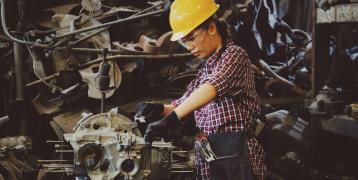 An image of a woman skillfully working with heavy machinery. 