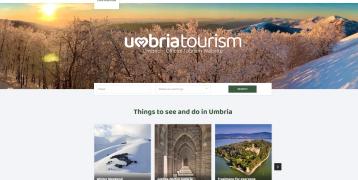 A screenshot of the Umbria Tourism home page showing a snowy scene